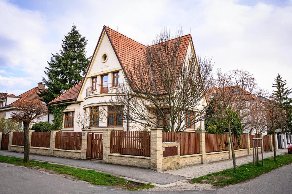 uma casa com uma cerca de madeira em frente em Vila Lumír em Poděbrady