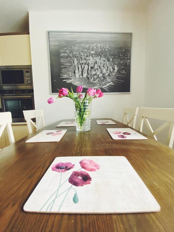 a table with pink flowers in a vase on it at Vila Lumír in Poděbrady