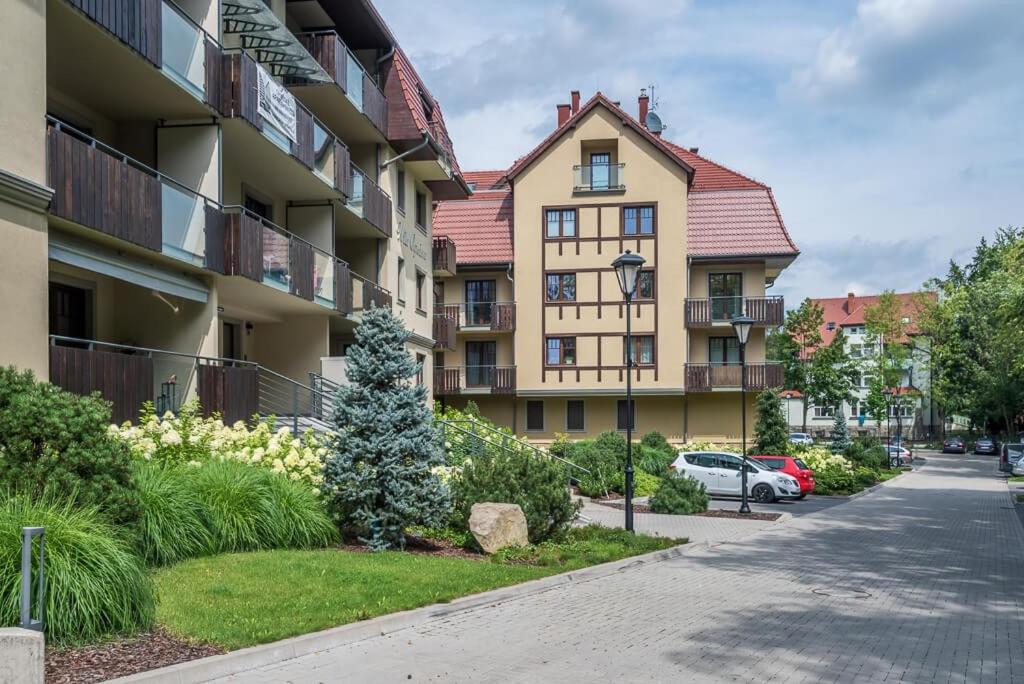 a apartment building with a driveway and a street at Apartament 26 Willa Ogrodowa in Polanica-Zdrój