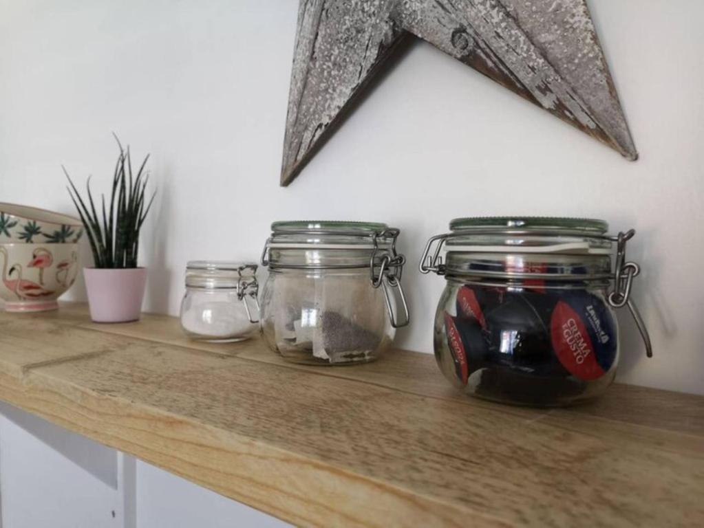 a wooden counter with jars of food on it at The Little House, boutique home near the sea in Chichester