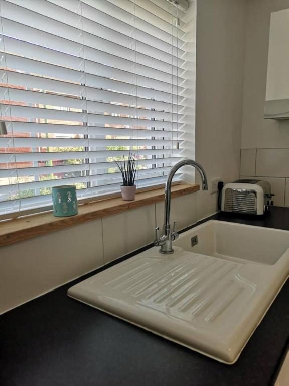 a kitchen counter with a sink and a window at The Little House, boutique home near the sea in Chichester