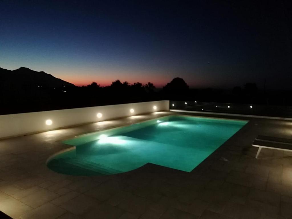 a swimming pool lit up at night at Il Volo Dei Gabbiani in Scopello