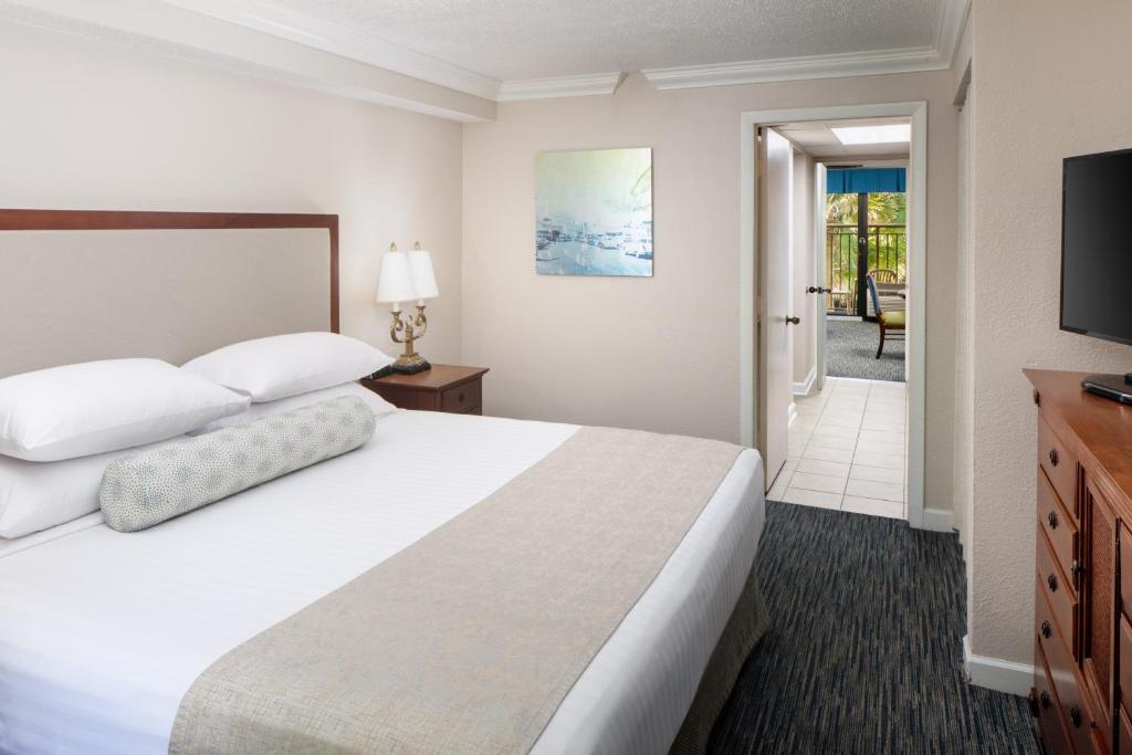 a hotel room with a bed and a television at Holiday Pavilion Resort on the Boardwalk in Myrtle Beach