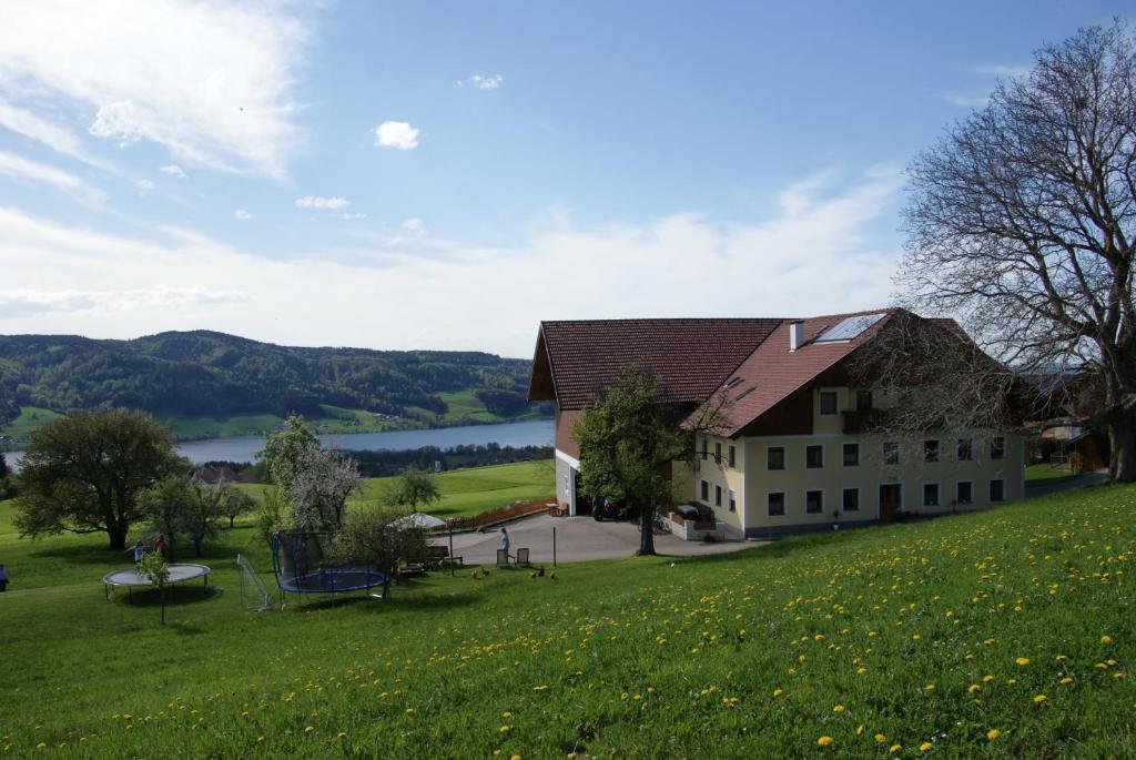 un gran edificio en una colina con un campo verde en Ferienhof Edtmeier, en Zell am Moos
