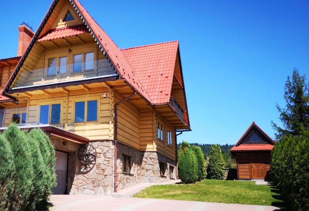 a log home with a red roof at Krasna Chata Maniowy in Maniowy