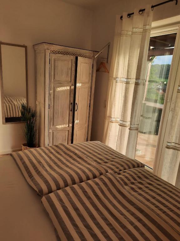 Schlafzimmer mit einem großen Bett und einem Fenster in der Unterkunft Ferienwohnung Erlenbach-Marktheidenfeld in Erlenbach bei Marktheidenfeld