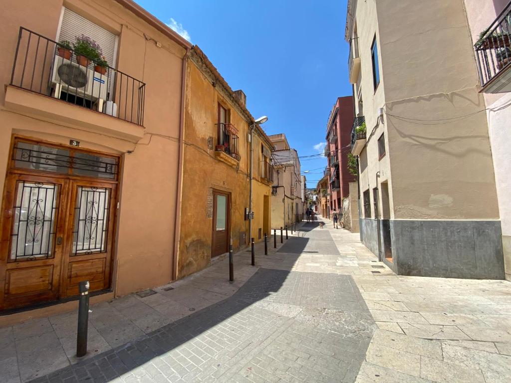 an empty street in an alley with buildings at The Yellow House by MyRentalHost in Barcelona