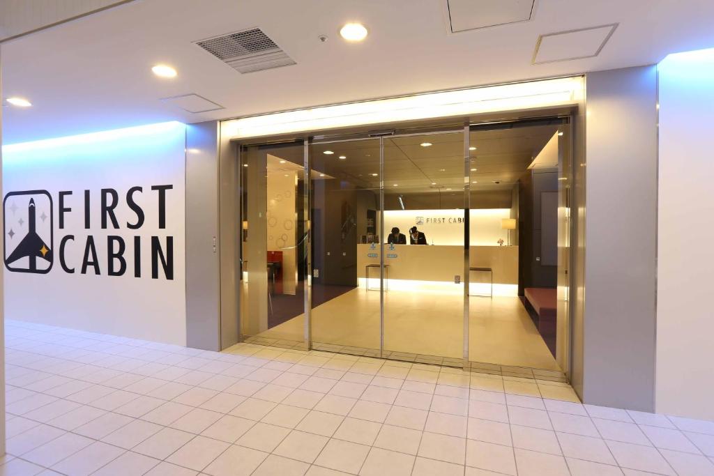 a store front with a first cabin sign on the wall at First Cabin Hakata in Fukuoka