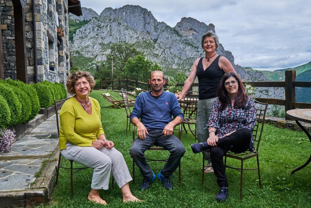 um grupo de pessoas sentadas em cadeiras na grama em La Posada de Cucayo em Dobres