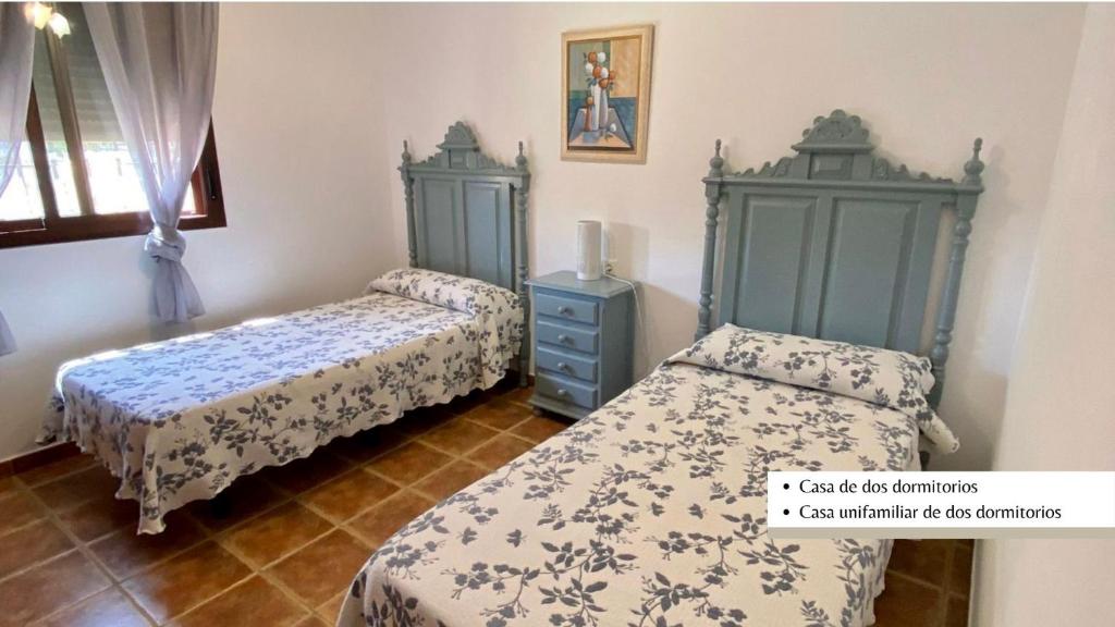 コニル・デ・ラ・フロンテーラにあるArco Casas Adosadasのベッドルーム1室(ベッド2台、青いキャビネット付)