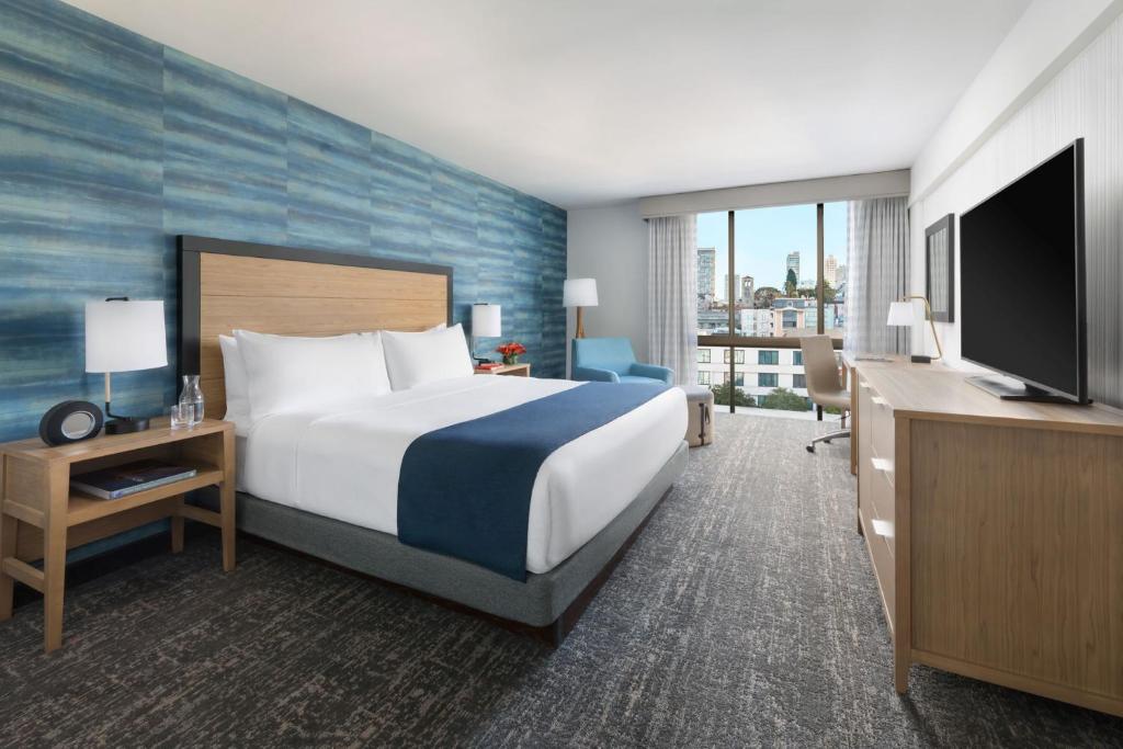 a hotel room with a large bed and a television at Hotel Caza Fisherman's Wharf in San Francisco