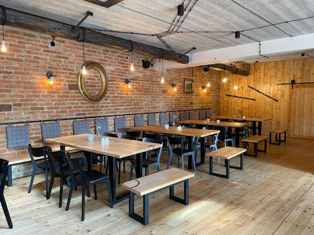 a restaurant with wooden tables and chairs and a brick wall at Penzion Kolnička in Luka nad Jihlavou