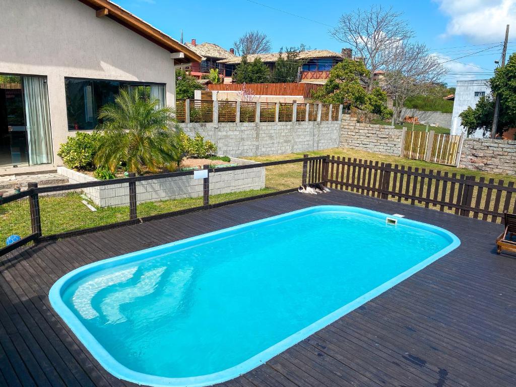 a swimming pool in a yard with a fence at Rosamar Suites in Praia do Rosa