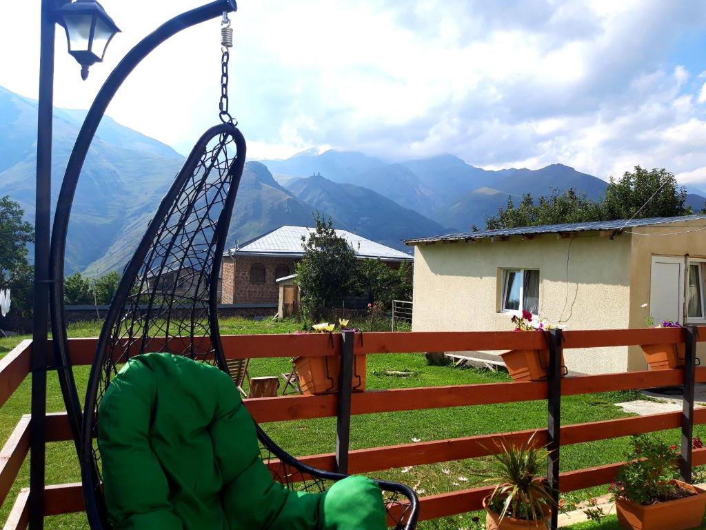 a swing on a porch with mountains in the background at Guest House Elguja Qushashvili in Stepantsminda