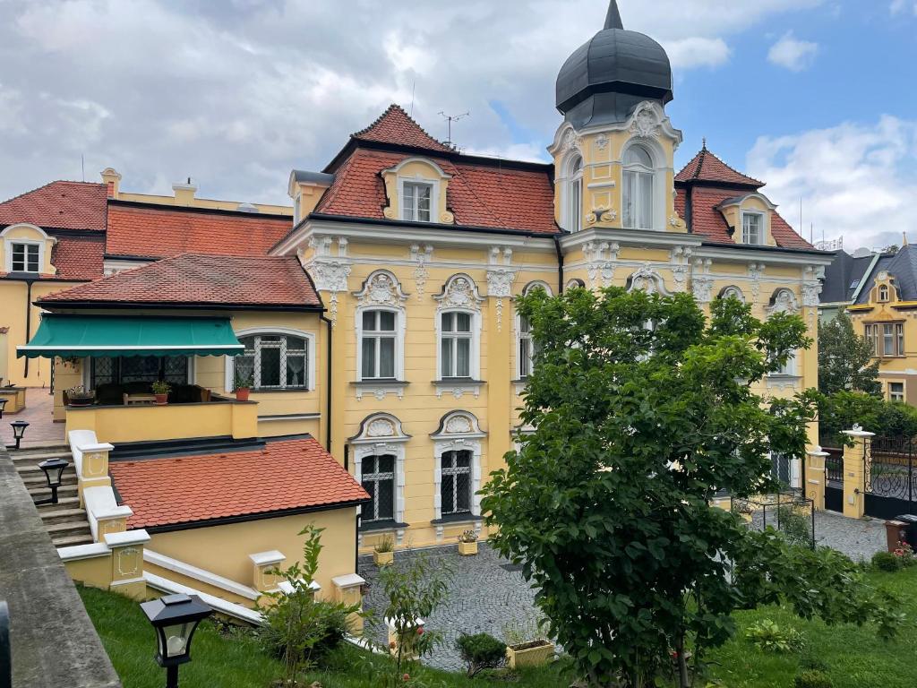 特普利採的住宿－Salve Teplice，一座黄色的大建筑,设有钟楼