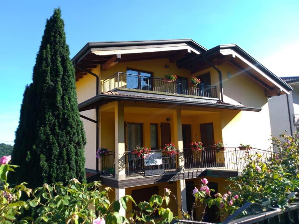 una casa amarilla con balcones y flores. en B&B MiraValle, en Scanzorosciate
