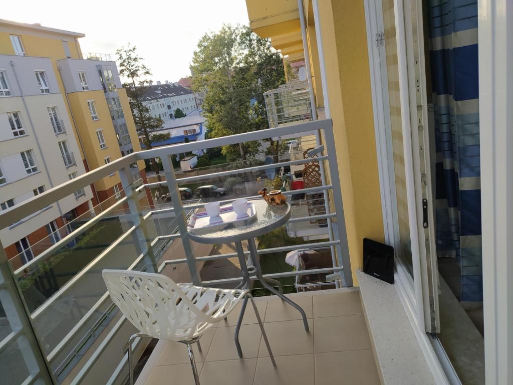 balcón con mesa y sillas en Przytulny apartament niedaleko centrum, en Szczecin