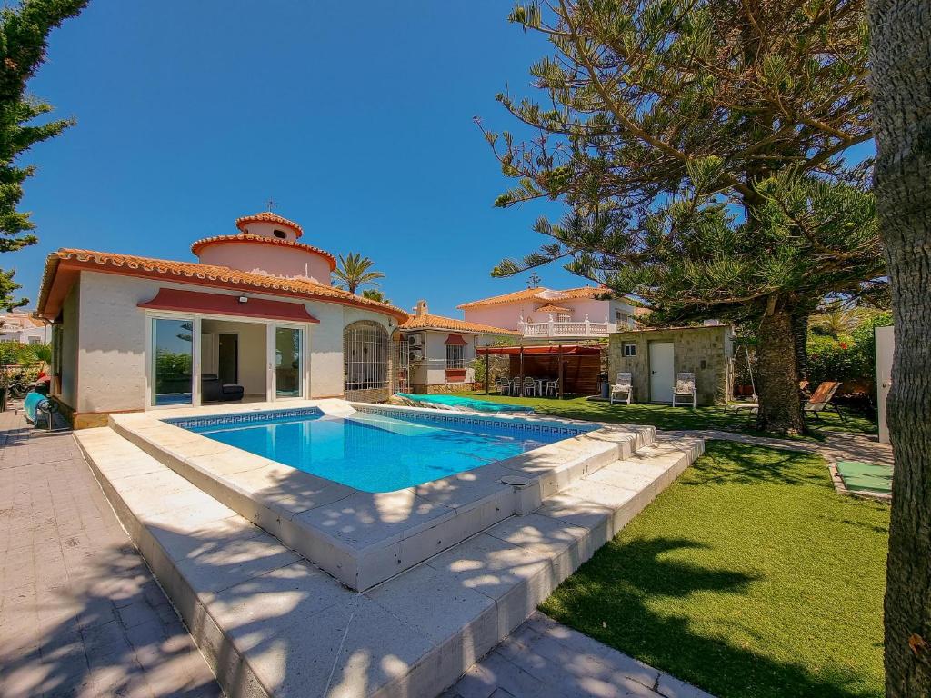 a swimming pool in the backyard of a house at Beachfront Villa Torrox Costa in Torrox Costa