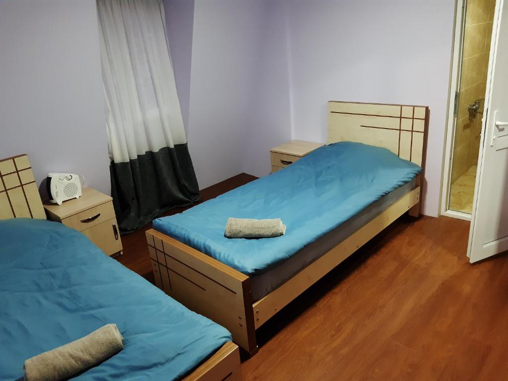 2 Betten in einem Zimmer mit blauer Bettwäsche in der Unterkunft Mate Private Rooms in Uschguli