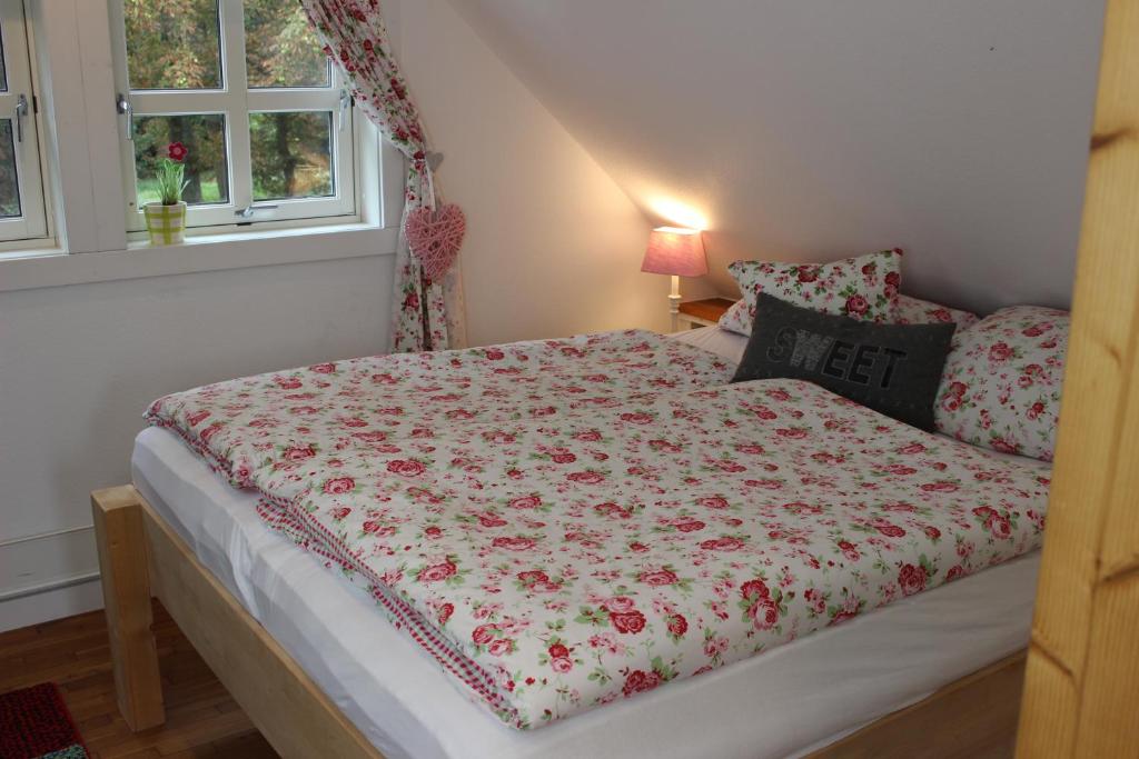 a bed with a floral comforter on it in a bedroom at gemütliches Gästezimmer in Ostseenähe in Stubbendorf