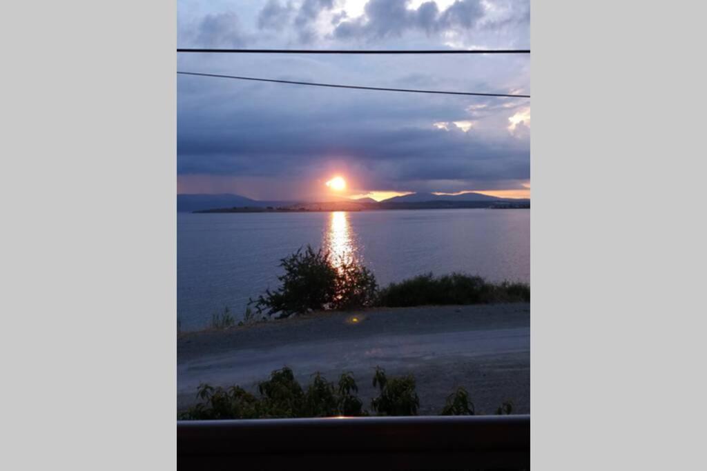 a view from a window of a sunset over the water at SUNSET-Denize sıfır konumda, eşyalı yazlık in Seferihisar