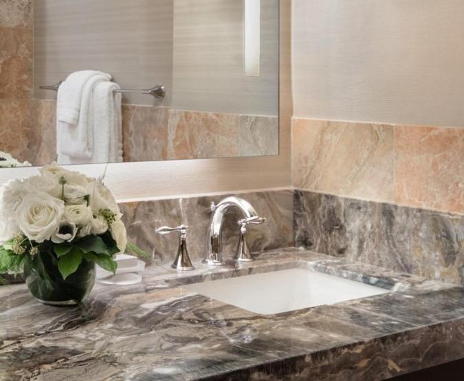 a bathroom with a sink and a vase of flowers at Trump International New York in New York