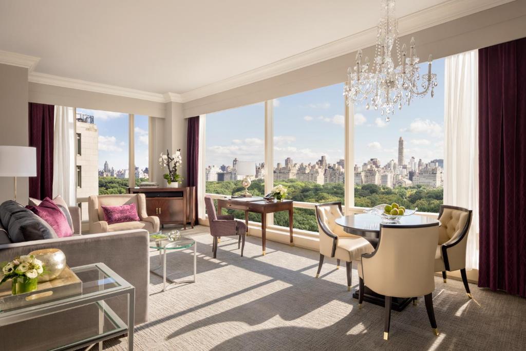 a living room with a chandelier and a large window at Trump International New York in New York