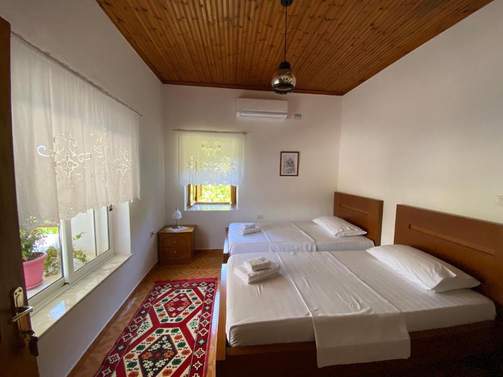 吉诺卡斯特Old Town Hotel的有两张床和一扇窗户的卧室