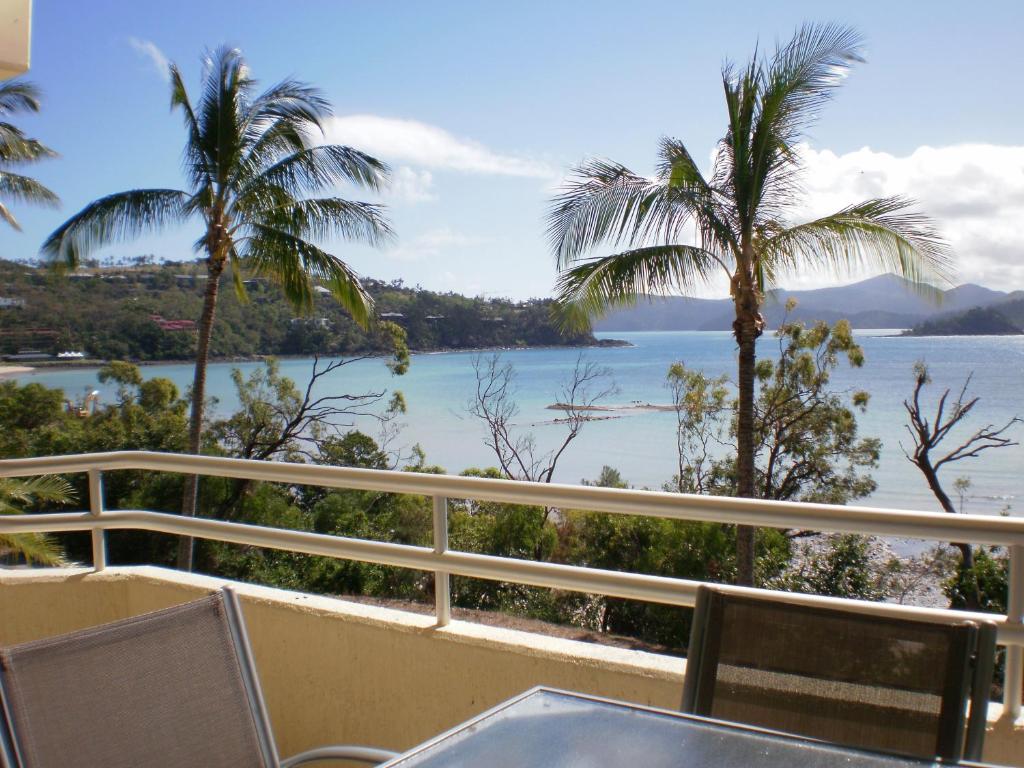 a view from the balcony of a resort with palm trees at Frangipani 103 - Hamilton Island in Hamilton Island