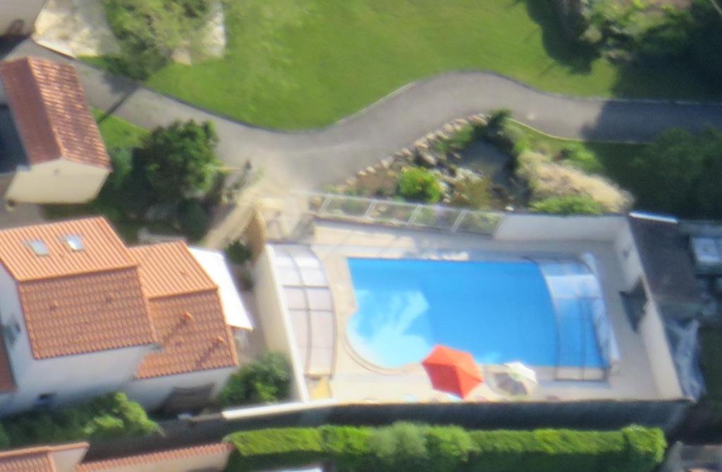 Cette chambre offre une vue sur une maison dotée d'une piscine. dans l'établissement Le Gîte de la Davière, à Le Boupère