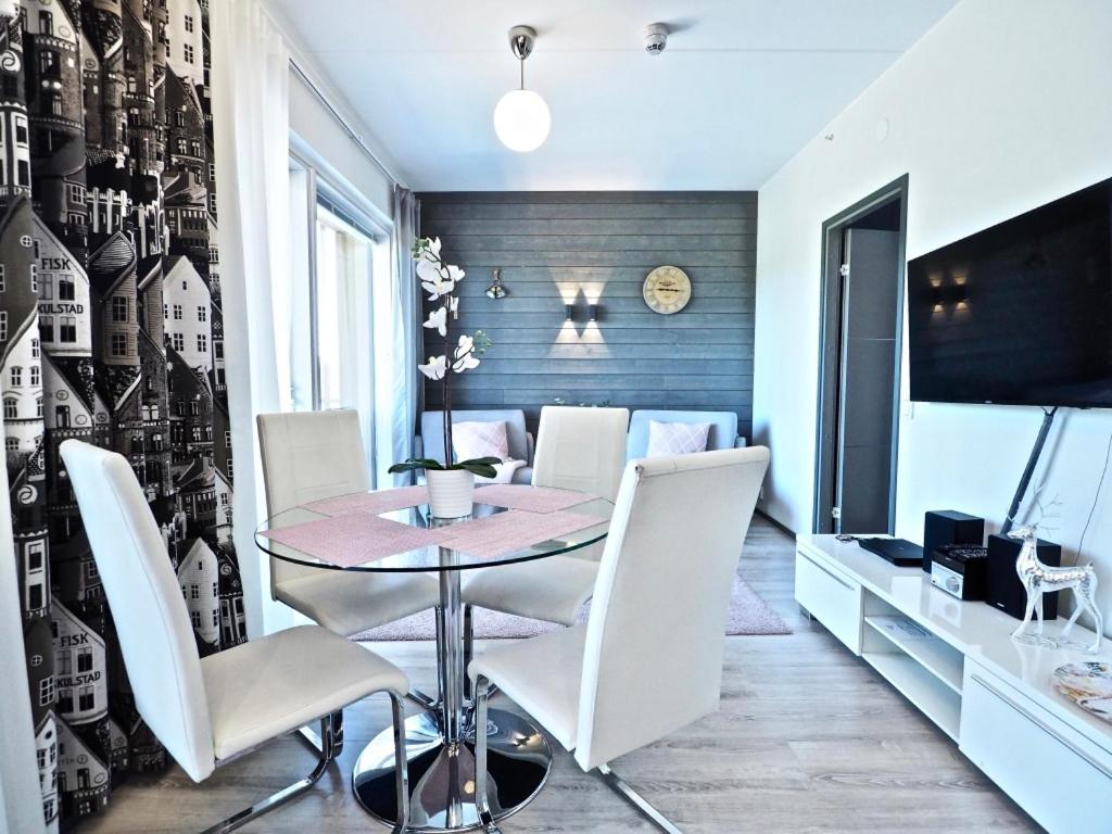 a dining room with a table and white chairs at Levin keskusta, Tunturinlaita B9 in Levi