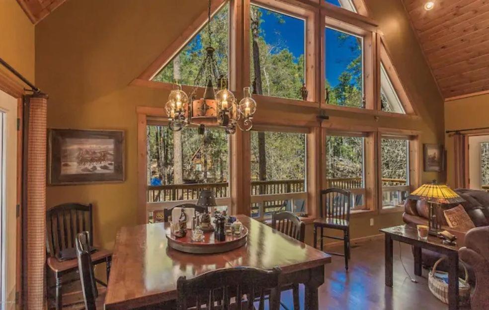 a dining room with a table and some windows at Chalet 5 Aspens in Prescott