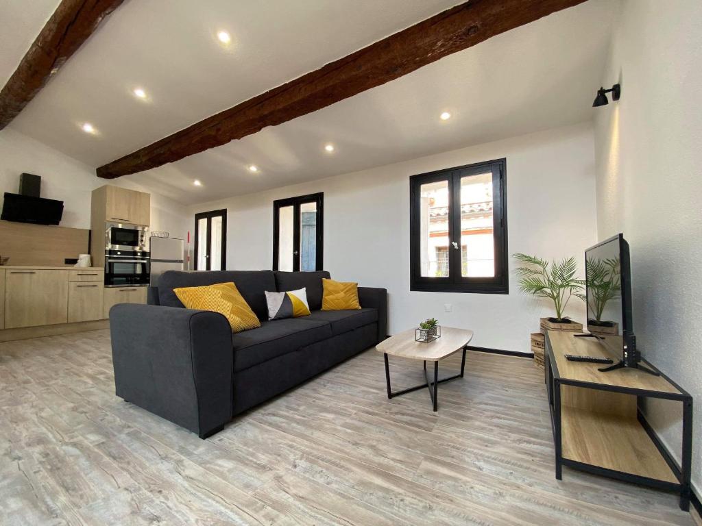 un salon avec un canapé et une table dans l'établissement Duplex des études - Carcassonne centre, à Carcassonne