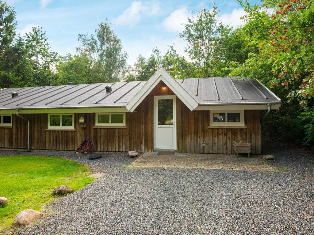 Casa de madera pequeña con puerta blanca en Two-Bedroom Holiday home in Oksbøl 10 en Ansager