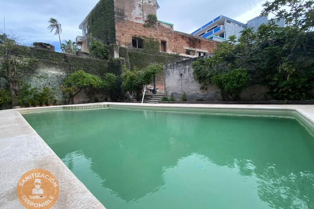 una piscina de agua verde frente a un edificio en CasaMelchers/AlbercaPrivada/CentroHistórico, en Mazatlán