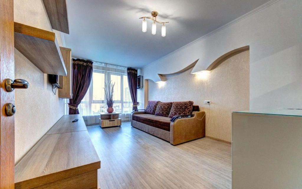 a living room with a couch and some windows at 1к квартира метро Лук'янівка, Юрія Іллєнка 49 in Kyiv