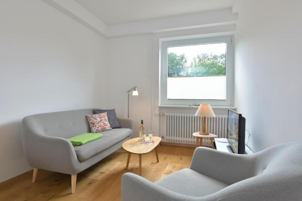 - un salon avec un canapé, deux chaises et une fenêtre dans l'établissement Dat Ferienhus - Utslaapen, à Malente