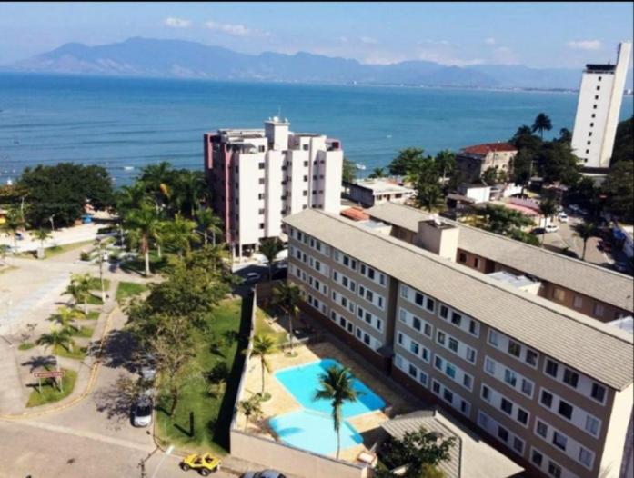 an aerial view of a building and the ocean at Apartamento Dona Frida Prainha com WiFi pé na areia in Caraguatatuba