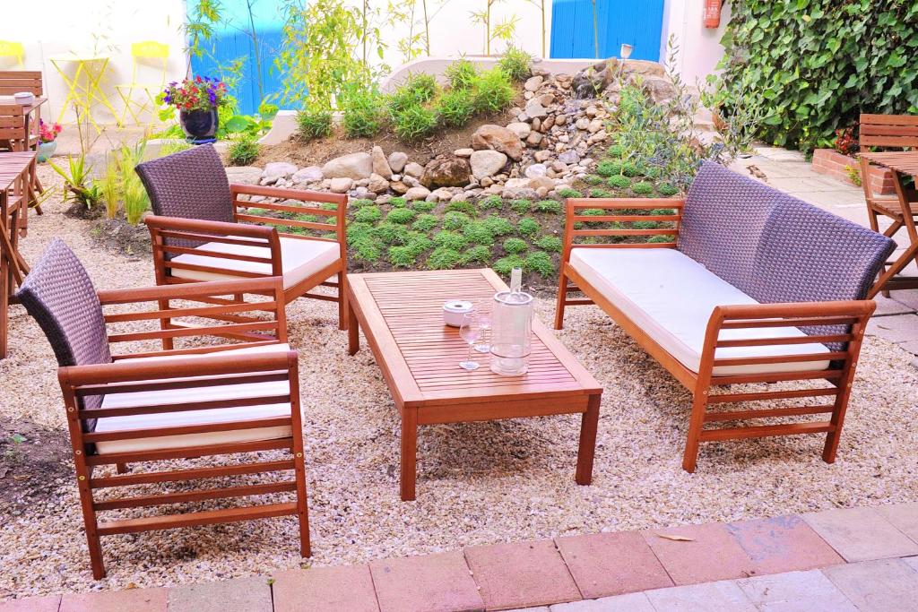 einer Gruppe von Stühlen und einem Holztisch und einem sidx sidx sidx sidx sidx in der Unterkunft Hotel Durand Le Patio in Alès
