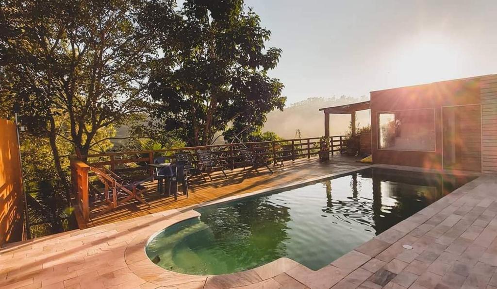 a swimming pool in front of a house at Pousada Pato Mergulhão in Vargem Bonita