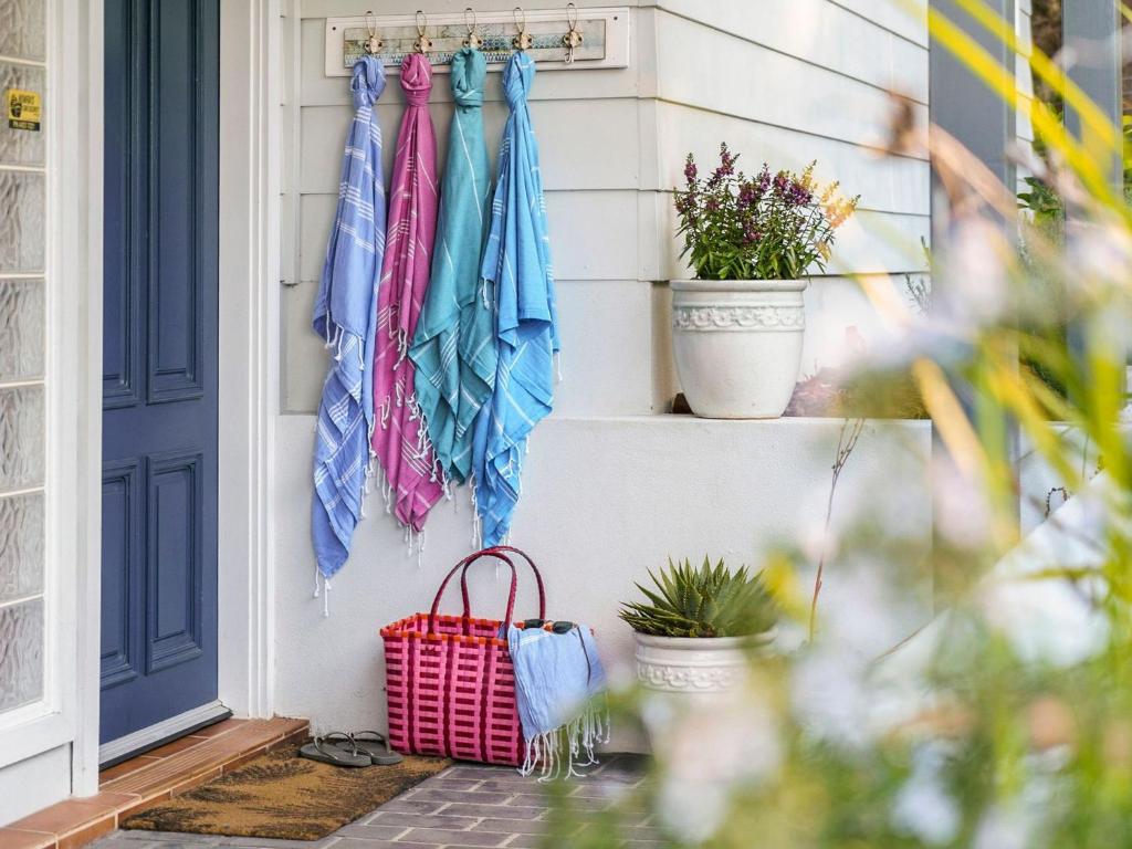 a door with umbrellas hanging on a wall at 24 Hyam Rd Hyams Beach in Hyams Beach