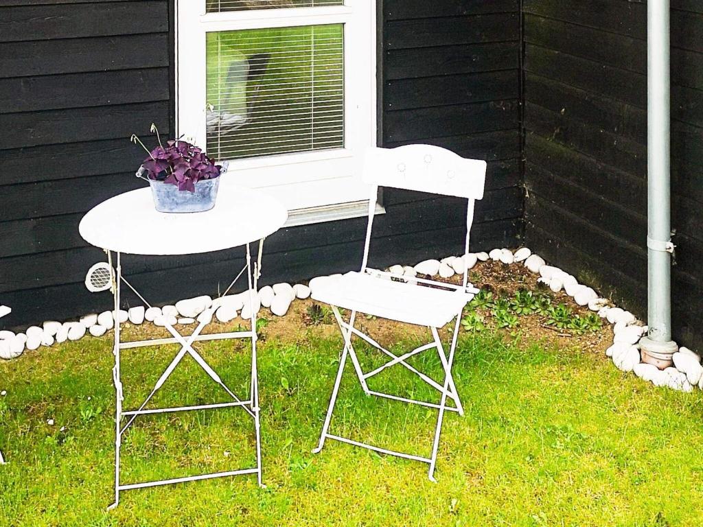 dos sillas y una mesa en el césped junto a una casa en 5 person holiday home in Malling, en Malling
