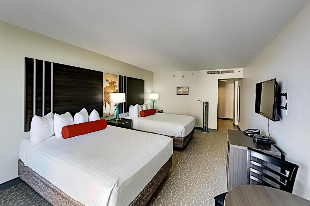 a hotel room with two beds and a flat screen tv at Aqua Palms Waikiki Ocean View Lanai Parking Included in Honolulu