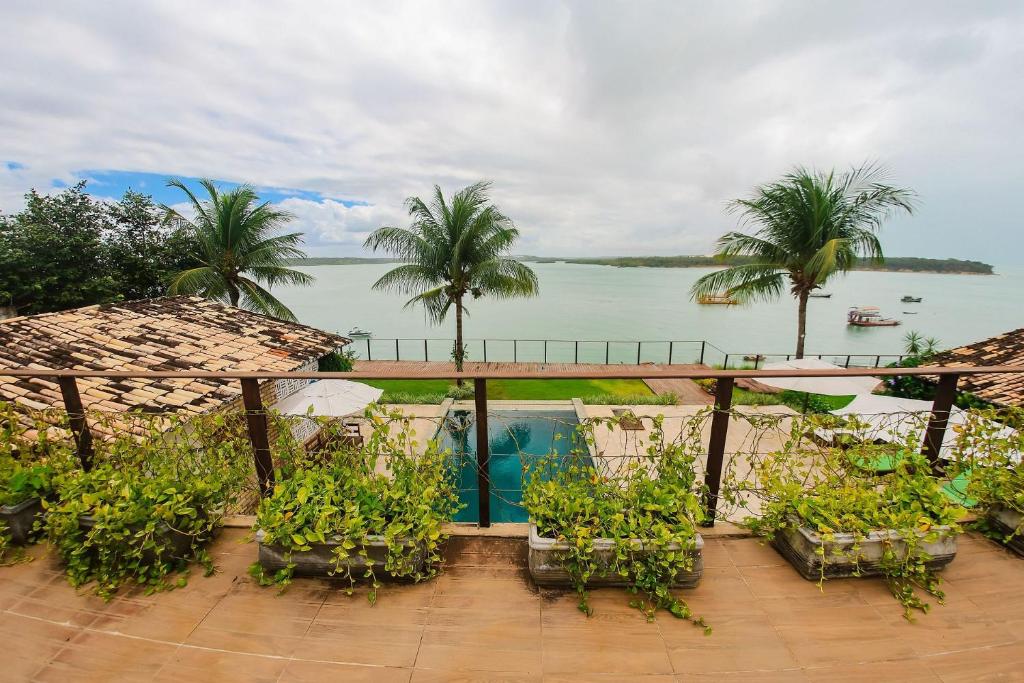 un balcón con plantas y vistas al agua en Qavi - Lagoa View, en Pipa