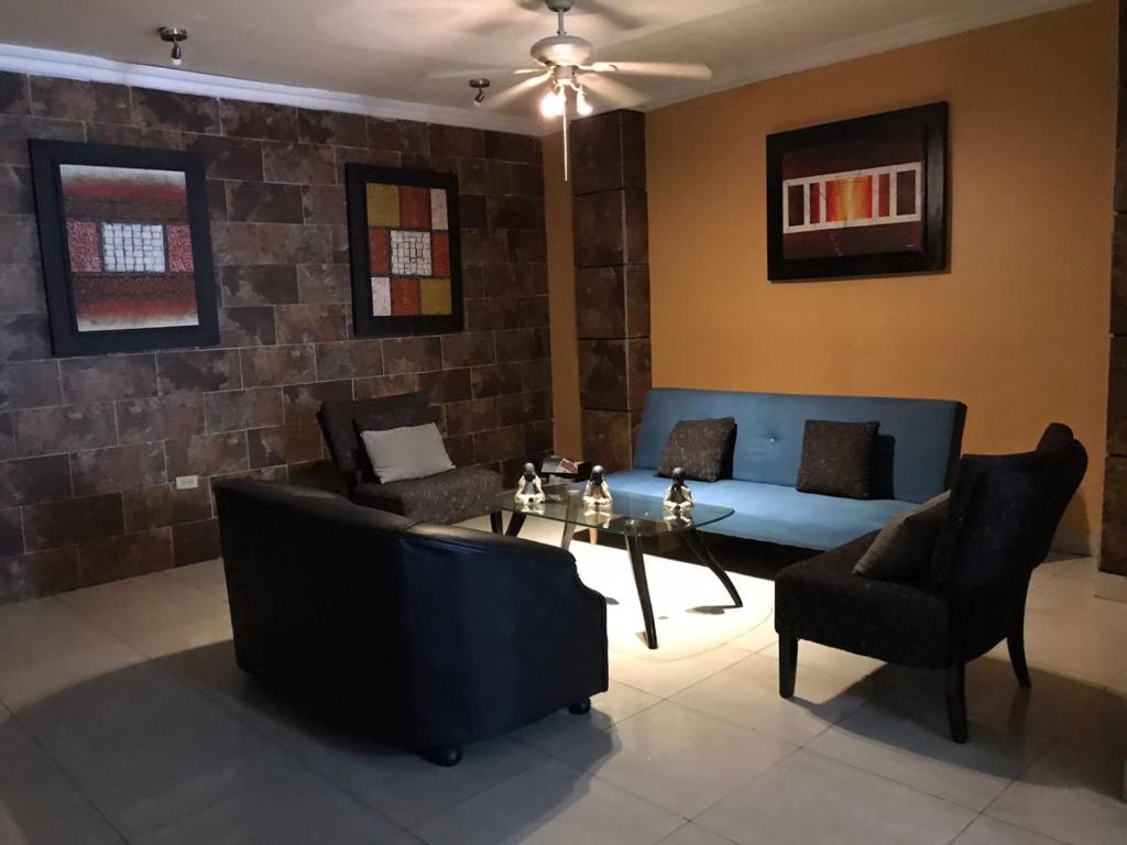 sala de estar con sofá, mesa y sillas en Hostal Bellagio, en Guayaquil