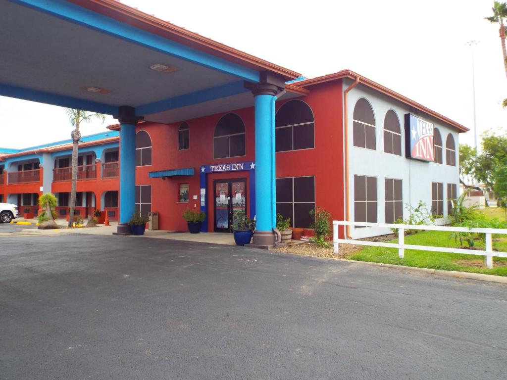 un edificio rojo y blanco con columnas azules en Texas Inn Harlingen, en Harlingen