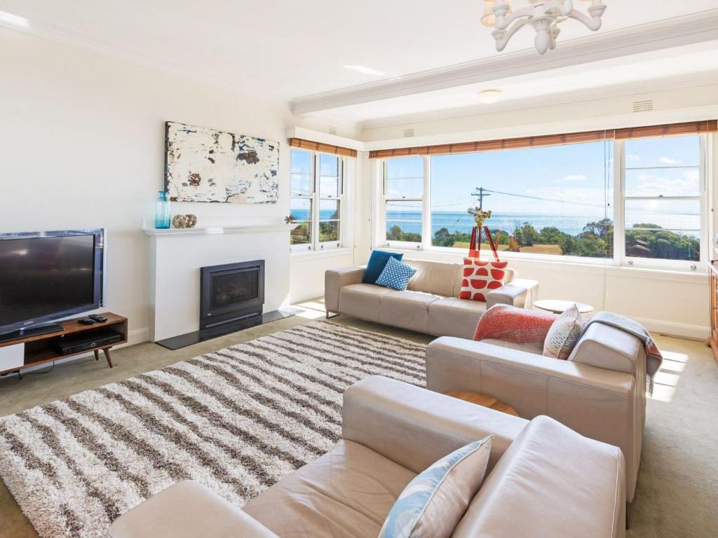 a living room with a fireplace and a tv at Beach Belle Mornington in Mornington