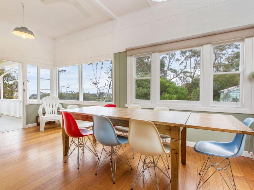 a dining room with a large wooden table and chairs at BEACHSIDE GETAWAY DROMANA in Dromana