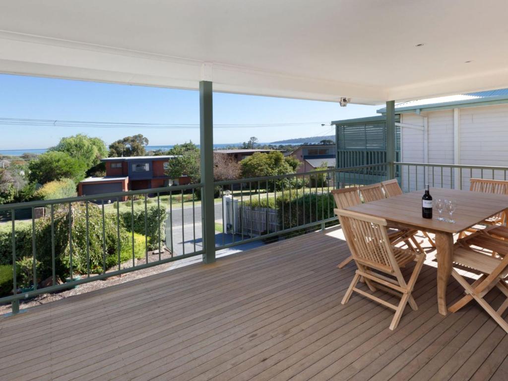 eine Holzterrasse mit einem Tisch und Stühlen darauf in der Unterkunft Dromana Bay Views Dromana in Dromana