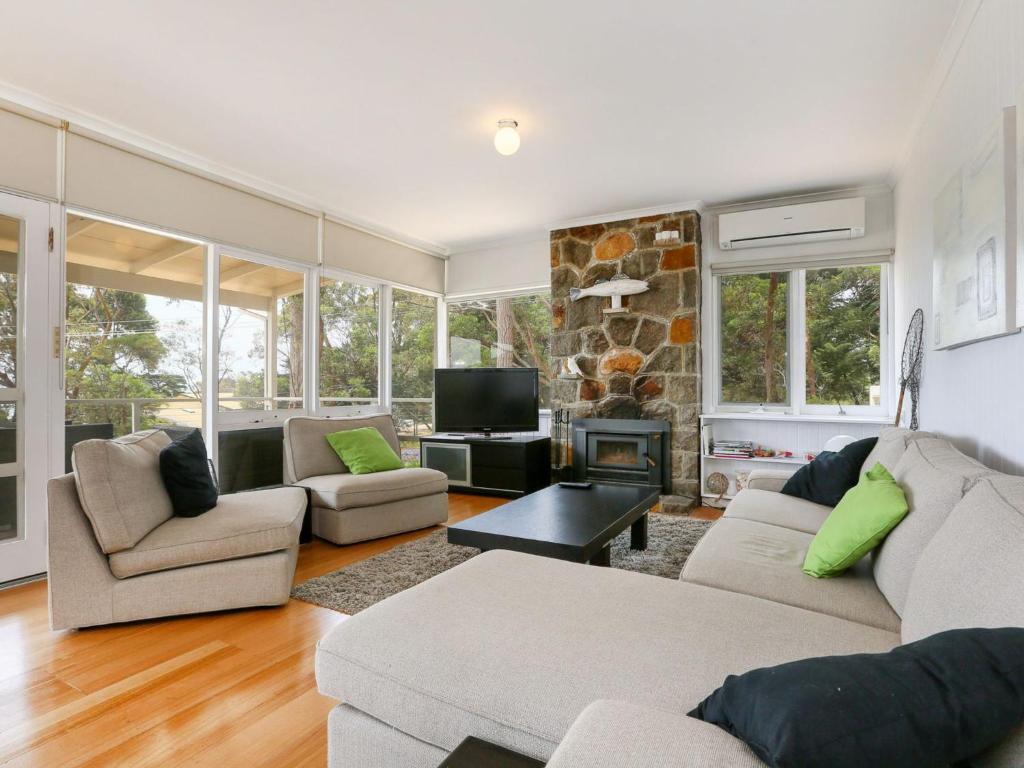 a living room with two couches and a fireplace at DROMANA BEACH SHACK in Dromana